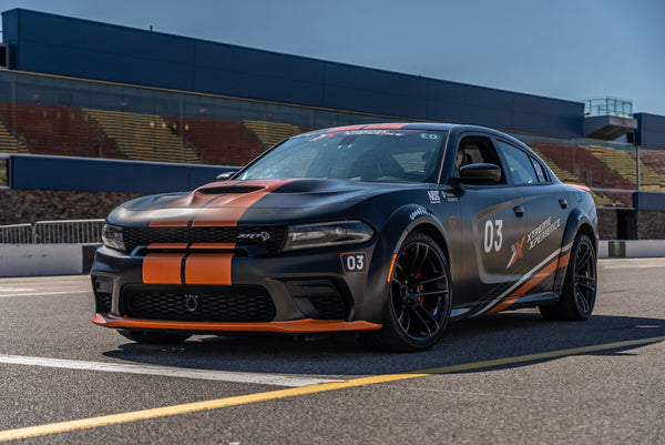 orange and black charger at racetrack