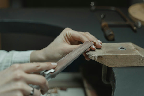 person working on spoon ring