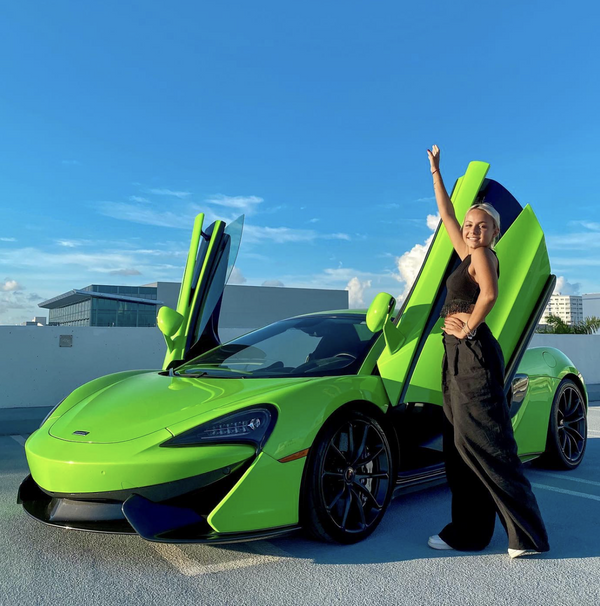 girl in front of mclaren on roof