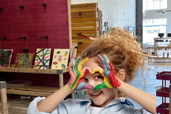 girl making heart with painted hands