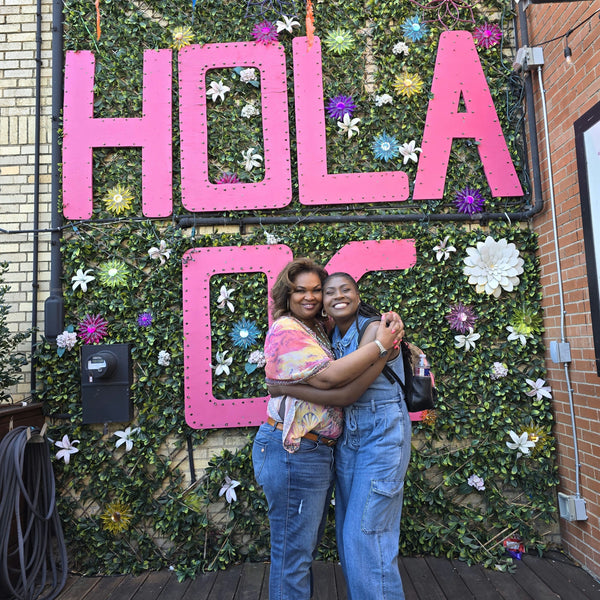 girls hugging in front of sign