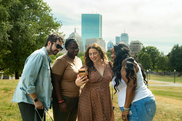 group of 4 looking at phone