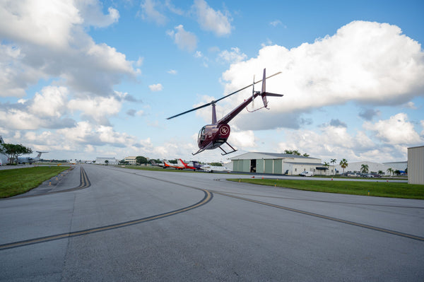 Helicopter flying over land and water with boats