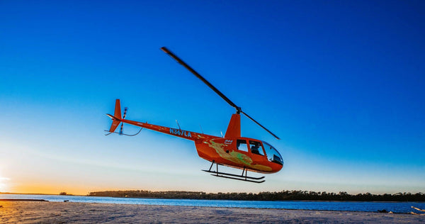 colorful helicopter on sand.webp