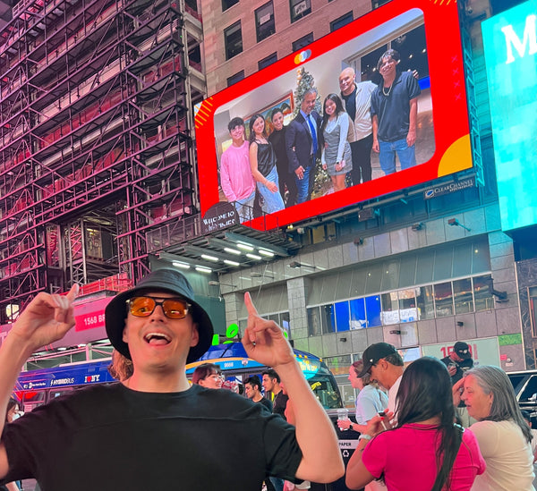 friends standing under photo on billboard