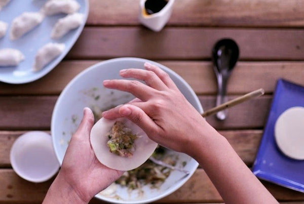 person wrapping dumpling