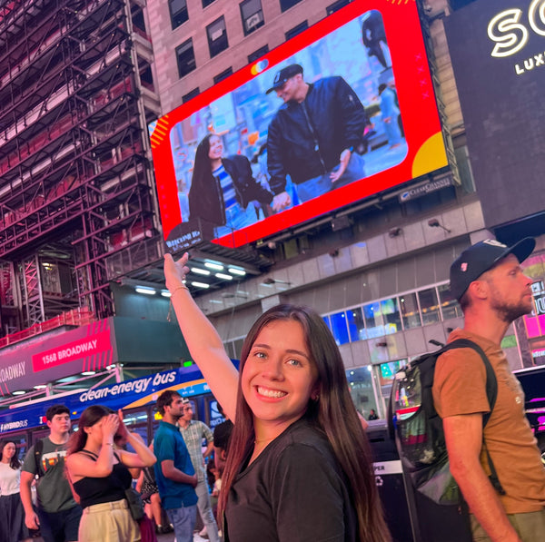 friends standing under photo on billboard