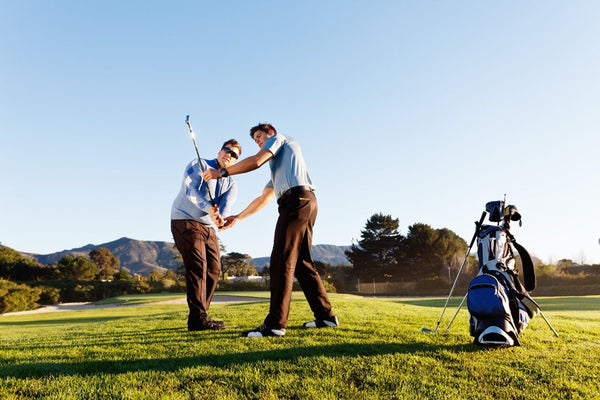 man and woman learning golf