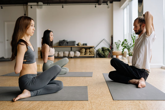 two women facing instructor in yoga class
