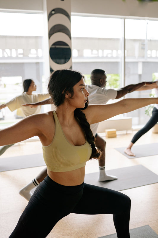 two women facing instructor in yoga class