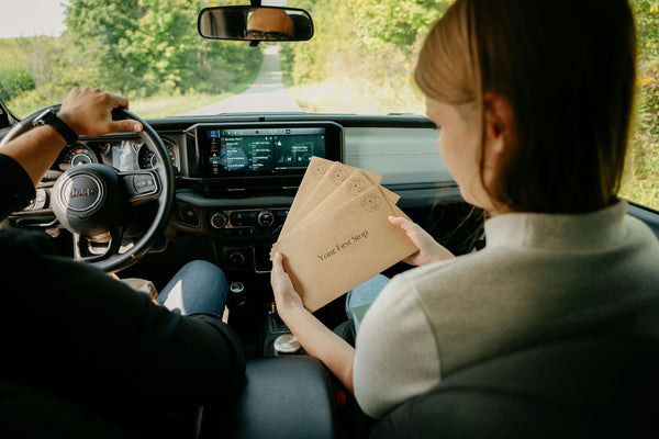 woman in passenger seat holding clues