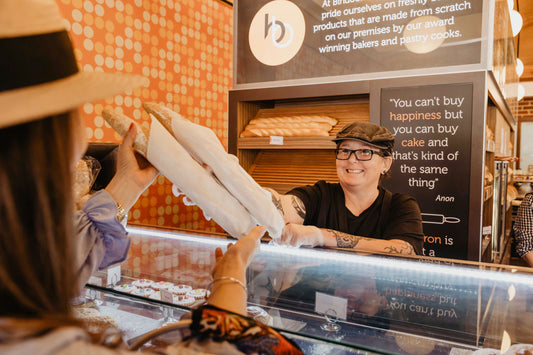 2 people getting baguettes for picnic