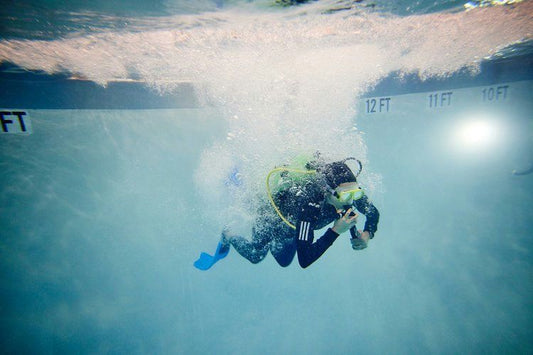 person in class diving underwater